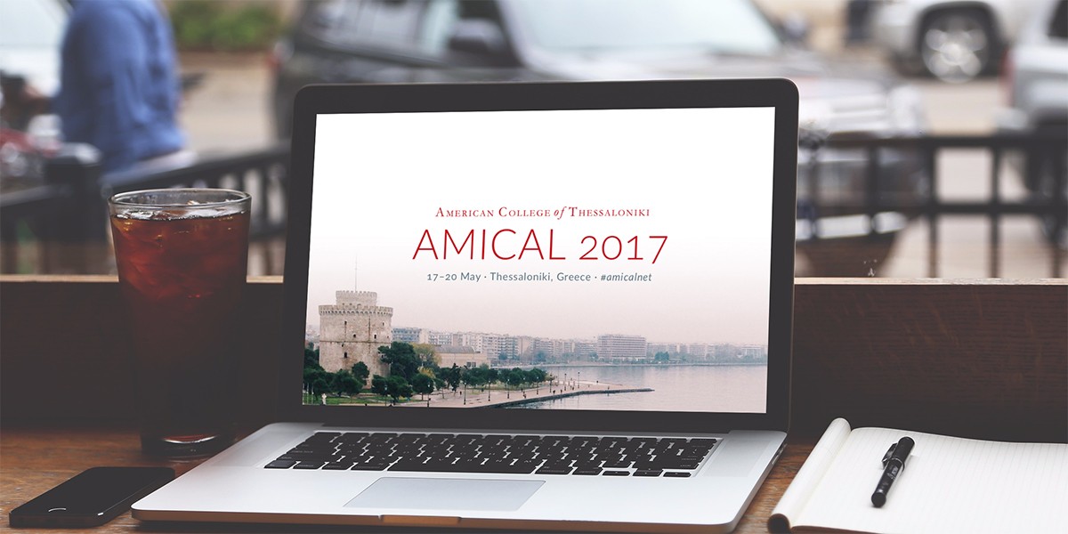 A laptop in a cafe showing the AMICAL 2017 banner.